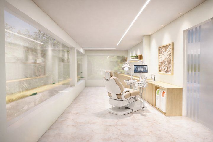 Bright treatment room with dental chair behind a glass partition